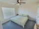 Bright bedroom featuring a ceiling fan, large window, and carpet floors at 1034 Se 65Th Cir, Ocala, FL 34472