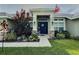 Inviting home entrance featuring a blue front door, decorative plants, and an American flag waving above at 1034 Se 65Th Cir, Ocala, FL 34472