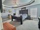 Spacious main bedroom with tray ceiling, fan, and windows, creating a peaceful and inviting retreat at 1034 Se 65Th Cir, Ocala, FL 34472
