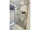 Main bath walk-in shower boasting sleek glass doors, tiled walls, seating and storage at 1034 Se 65Th Cir, Ocala, FL 34472