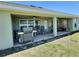 Covered patio featuring ceiling fans, outdoor seating, and a grill for relaxing or entertaining at 1034 Se 65Th Cir, Ocala, FL 34472