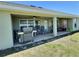 Covered patio featuring ceiling fans, outdoor furniture, and a grill, perfect for entertaining at 1034 Se 65Th Cir, Ocala, FL 34472