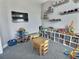 Bright playroom with gray carpet, built-in shelving, and a wall-mounted TV perfect for creative play and entertainment at 1034 Se 65Th Cir, Ocala, FL 34472