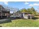 Backyard view featuring a pool, screened enclosure, and an outdoor building with a manicured lawn at 10910 Sw 47Th Ct, Ocala, FL 34476