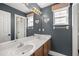 Bathroom boasts dual sinks, dark blue walls, with baseball themed decorations and bright vanity lighting at 10910 Sw 47Th Ct, Ocala, FL 34476