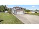 A two-story home with a spacious driveway and attached two-car garage nestled on a lush green lawn at 10910 Sw 47Th Ct, Ocala, FL 34476