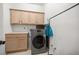 Neutral laundry room with light wood cabinets above the gray washer and dryer, and a countertop folding area at 10910 Sw 47Th Ct, Ocala, FL 34476