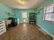 Bright laundry room with tile floors, washer, dryer, storage shelves, and a utility sink at 1370 Nw 120Th Ave, Ocala, FL 34482