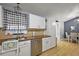 Bright kitchen featuring white cabinets, stainless steel appliances, and a view of the dining area at 33827 Silver Pine Dr, Leesburg, FL 34788