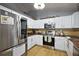 Well-equipped kitchen featuring white cabinetry, stainless steel appliances, and modern countertops at 33827 Silver Pine Dr, Leesburg, FL 34788