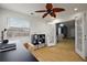 Inviting office featuring french doors, wood-look floors, fan, and a black desk with an organized bookshelf at 33827 Silver Pine Dr, Leesburg, FL 34788