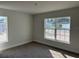 Well-lit bedroom featuring neutral walls, plush carpeting and a view through large windows at 4397 Sw 90Th Pl, Ocala, FL 34476