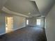 Large bedroom with neutral walls, carpet, tray ceiling, and an open doorway leading to other spaces at 4397 Sw 90Th Pl, Ocala, FL 34476