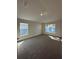 Spacious bedroom featuring neutral colored walls and carpet, as well as two windows at 4413 Sw 90Th Pl, Ocala, FL 34476