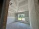 Unfinished bedroom featuring drywall, vaulted ceilings, and large window views of the exterior at 4413 Sw 90Th Pl, Ocala, FL 34476