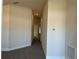 Long hallway features neutral paint, and carpet flooring, connecting the various rooms of the house at 4413 Sw 90Th Pl, Ocala, FL 34476