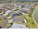 Aerial view of neighborhood homes and waterfront, highlighting solar panels and screened pool at 5766 Henry Loop, The Villages, FL 32163