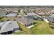 Aerial view showcasing the home's backyard, solar panels on a nearby roof, and a screened-in pool at 5766 Henry Loop, The Villages, FL 32163