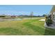 Backyard view with pond, healthy green grass and lush landscaping at 5766 Henry Loop, The Villages, FL 32163