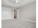 Bright, carpeted bedroom with ceiling fan, closet, and open door to hallway at 5766 Henry Loop, The Villages, FL 32163