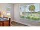 Bedroom showcasing large windows with backyard views of palm trees and the nearby lake at 5766 Henry Loop, The Villages, FL 32163