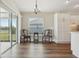 Bright dining area features wood-look flooring, natural light, with a stylish light fixture at 5766 Henry Loop, The Villages, FL 32163