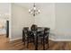 Dining room featuring a modern chandelier, dark wood table, hardwood floors, and a view of the kitchen at 5766 Henry Loop, The Villages, FL 32163