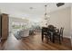 Open-concept living and dining room featuring hardwood floors and view of the lanai and kitchen at 5766 Henry Loop, The Villages, FL 32163