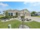 Charming home featuring a three-car garage, well-maintained landscaping, and a decorative concrete driveway at 5766 Henry Loop, The Villages, FL 32163