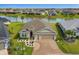 Beautiful home featuring a tranquil pond view, well-manicured lawn, and a spacious driveway with a unique compass design at 5766 Henry Loop, The Villages, FL 32163
