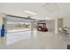 Spacious garage with epoxy flooring, ample lighting, and a golf cart, offering plenty of room for vehicles and storage at 5766 Henry Loop, The Villages, FL 32163