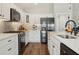 Well-equipped kitchen with stainless steel appliances, white cabinets, and ample counter space at 5766 Henry Loop, The Villages, FL 32163