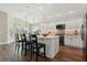 Modern kitchen with island seating, white cabinets, and stainless steel appliances at 5766 Henry Loop, The Villages, FL 32163