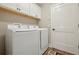 Bright laundry room equipped with a modern washer and dryer, and overhead cabinets at 5766 Henry Loop, The Villages, FL 32163