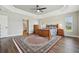 Large main bedroom features a tray ceiling, wood floors, ceiling fan and bright windows at 5766 Henry Loop, The Villages, FL 32163