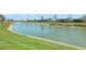 Waterfront view of the community canal with lush grassy banks and views of the neighboring homes in the distance at 5766 Henry Loop, The Villages, FL 32163