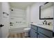 Bright bathroom featuring blue vanity, framed mirror, and shower with tub at 7014 Elaine Ct, The Villages, FL 34762