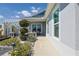 Charming front yard with decorative plants and a pergola providing shade to an outdoor seating area at 7014 Elaine Ct, The Villages, FL 34762