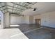 View of open garage with overhead door, window, storage room and coated floor at 7014 Elaine Ct, The Villages, FL 34762