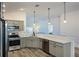 Well-lit kitchen features stainless steel appliances, gray cabinets, and modern countertops at 7014 Elaine Ct, The Villages, FL 34762