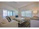 Bright living room with neutral decor, wood floors and sliding glass doors to screened porch at 7014 Elaine Ct, The Villages, FL 34762