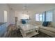 Bright living room with neutral decor, wood floors and sliding glass doors to screened porch at 7014 Elaine Ct, The Villages, FL 34762