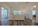 Bright living room with neutral decor, wood floors and sliding glass doors to screened porch at 7014 Elaine Ct, The Villages, FL 34762