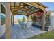 Inviting outdoor dining area with covered pergola, elegant table set and bougainvillea covered wall at 7014 Elaine Ct, The Villages, FL 34762