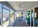 Covered screened patio with ceiling fan, dining table, and view to outdoor water feature at 7014 Elaine Ct, The Villages, FL 34762