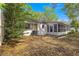 Backyard view of the home featuring mature trees, screen room and an AC unit at 8700 Sw 98Th Street Rd # E, Ocala, FL 34481