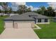 Aerial view of single Gathering home with a three car garage, manicured lawn, and neutral blue paint at 9975 Sw 39Th Ter, Ocala, FL 34476