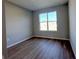 Empty bedroom with wood-look floors, a window view, and neutral walls at 9975 Sw 39Th Ter, Ocala, FL 34476