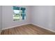 Bright, modern bedroom with a large window offering an outside view and wood-look vinyl flooring at 9975 Sw 39Th Ter, Ocala, FL 34476