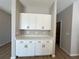White kitchen cabinets and countertop with black handles at 9975 Sw 39Th Ter, Ocala, FL 34476